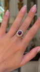 red tourmaline and diamond cluster ring, worn on hand and moved away from lens to give perspective, front view. 