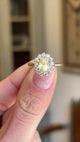 Video of a yellow gold antique-inspired yellow sapphire and diamond cluster engagement ring held between 2 fingers and rotated to show all angles.