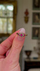 Antique, Edwardian Ruby and Diamond Cluster Ring, held in fingers and rotated to give perspective.