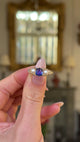 antique sapphire and pearl three stone ring held in fingers and moved around to give perspective.