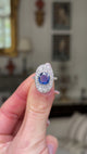 Edwardian sapphire and diamond ring,  held in fingers and rotated to give perspective.