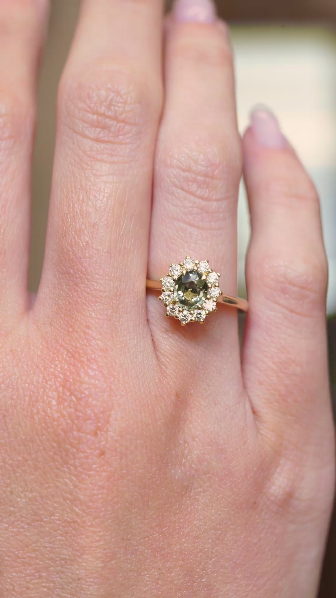 A video of an antique-inspired green sapphire and diamond engagement ring displayed on the hand in yellow gold.