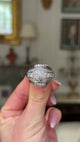 impressive Art Deco diamond bombe ring, held in fingers and rotated to give perspective, front view. 