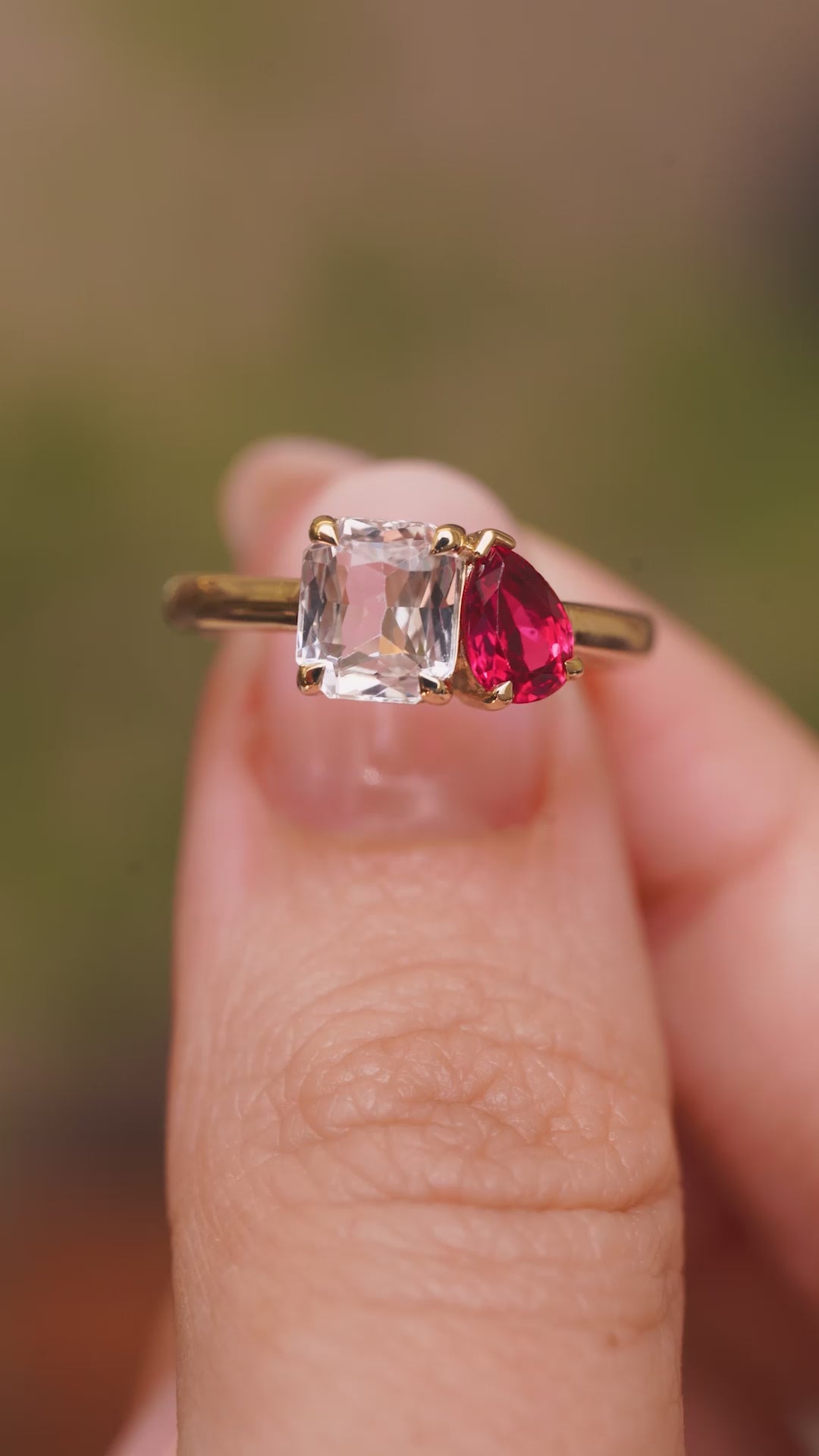 a video of an Antique-inspired, Pink sapphire and spinel Toi et Moi engagement ring held between fingers and rotated