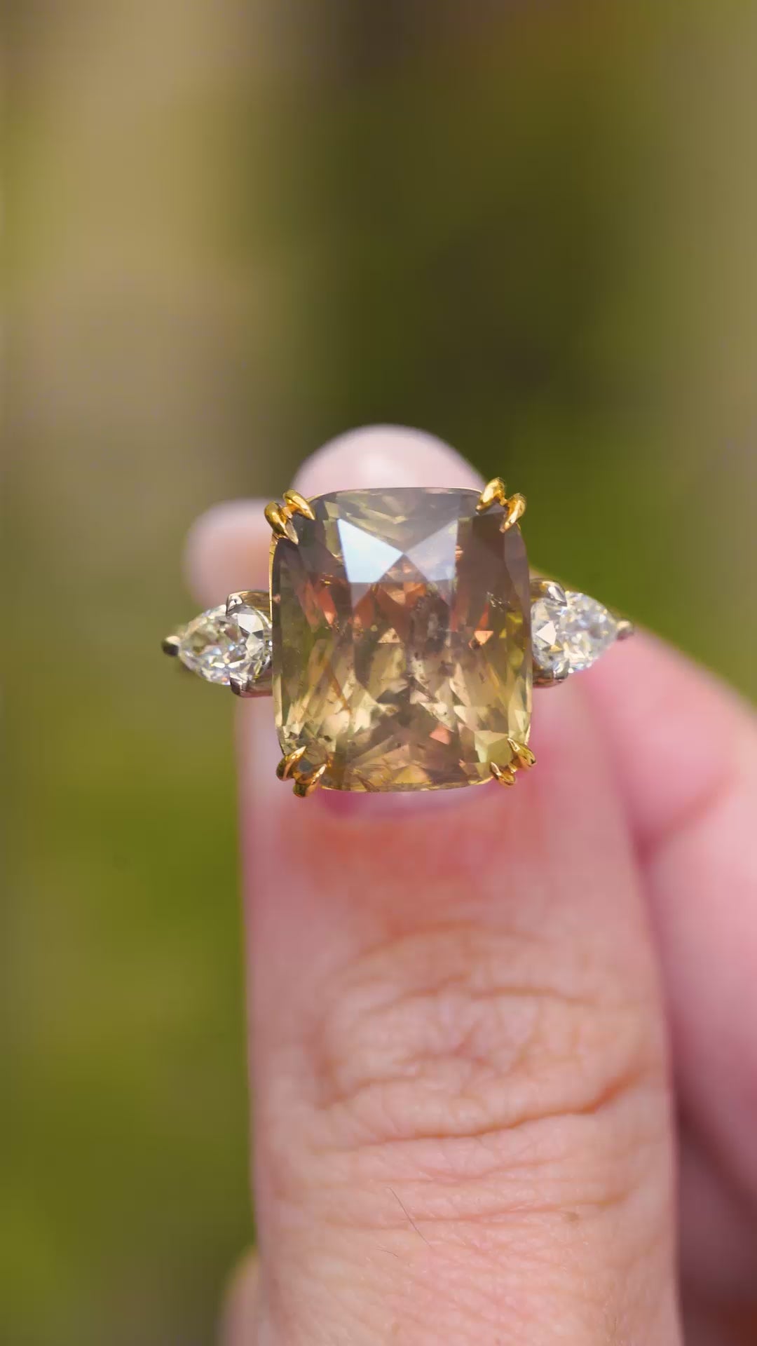 A video of a close-up of a large cushion-cut brown sapphire flanked by pear-shaped diamonds.