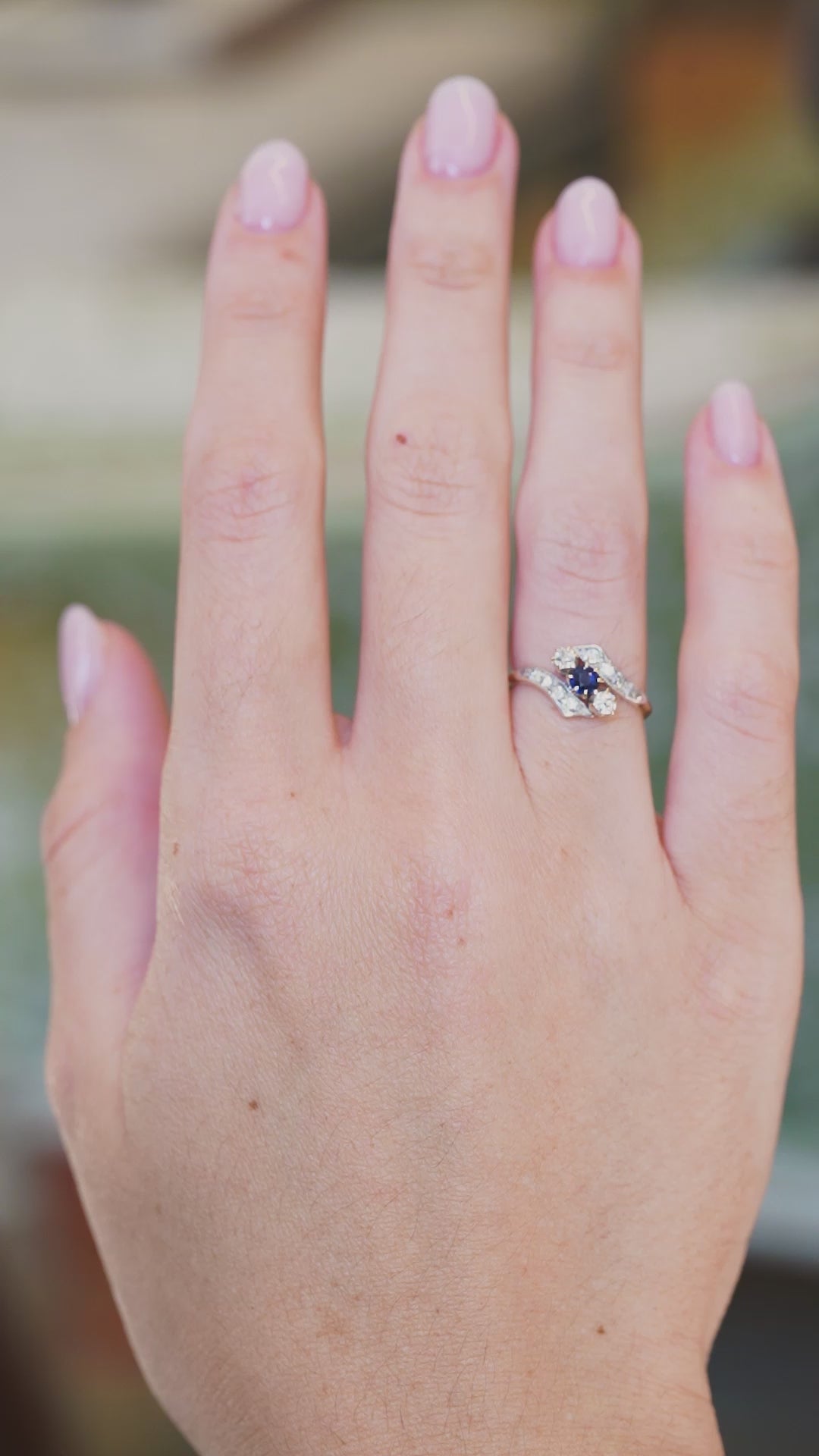 Edwardian sapphire twist ring with diamond band worn on hand
