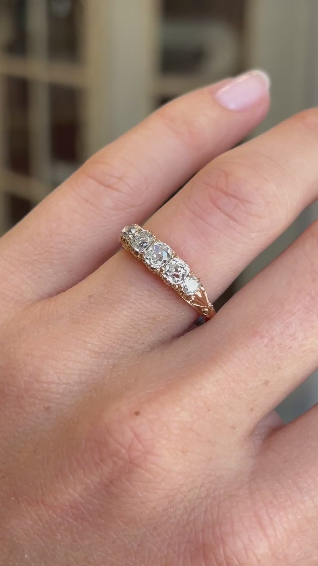 Antique Victorian old-mine diamond five-stone ring featuring five graduated old-mine cut diamonds, displayed on a hand.