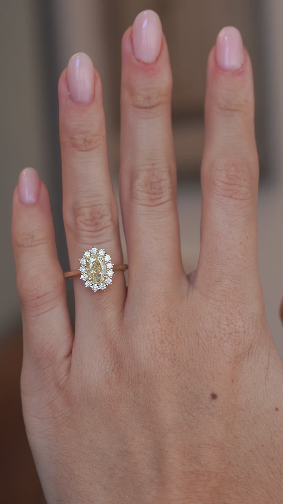Video: Yellow diamond cluster ring worn on a finger, capturing the sparkle of the central diamond and surrounding halo.