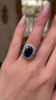 A vintage sapphire and diamond cluster ring worn on hand and moved around to give perspective.