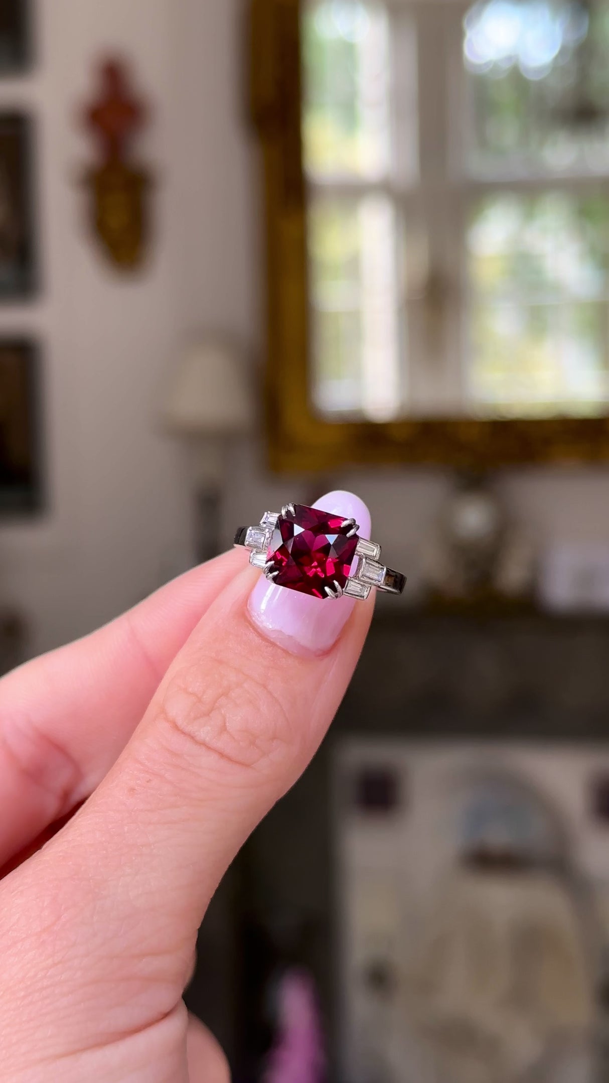 Vintage red garnet and diamond ring, held in fingers and moved around to give perspective.