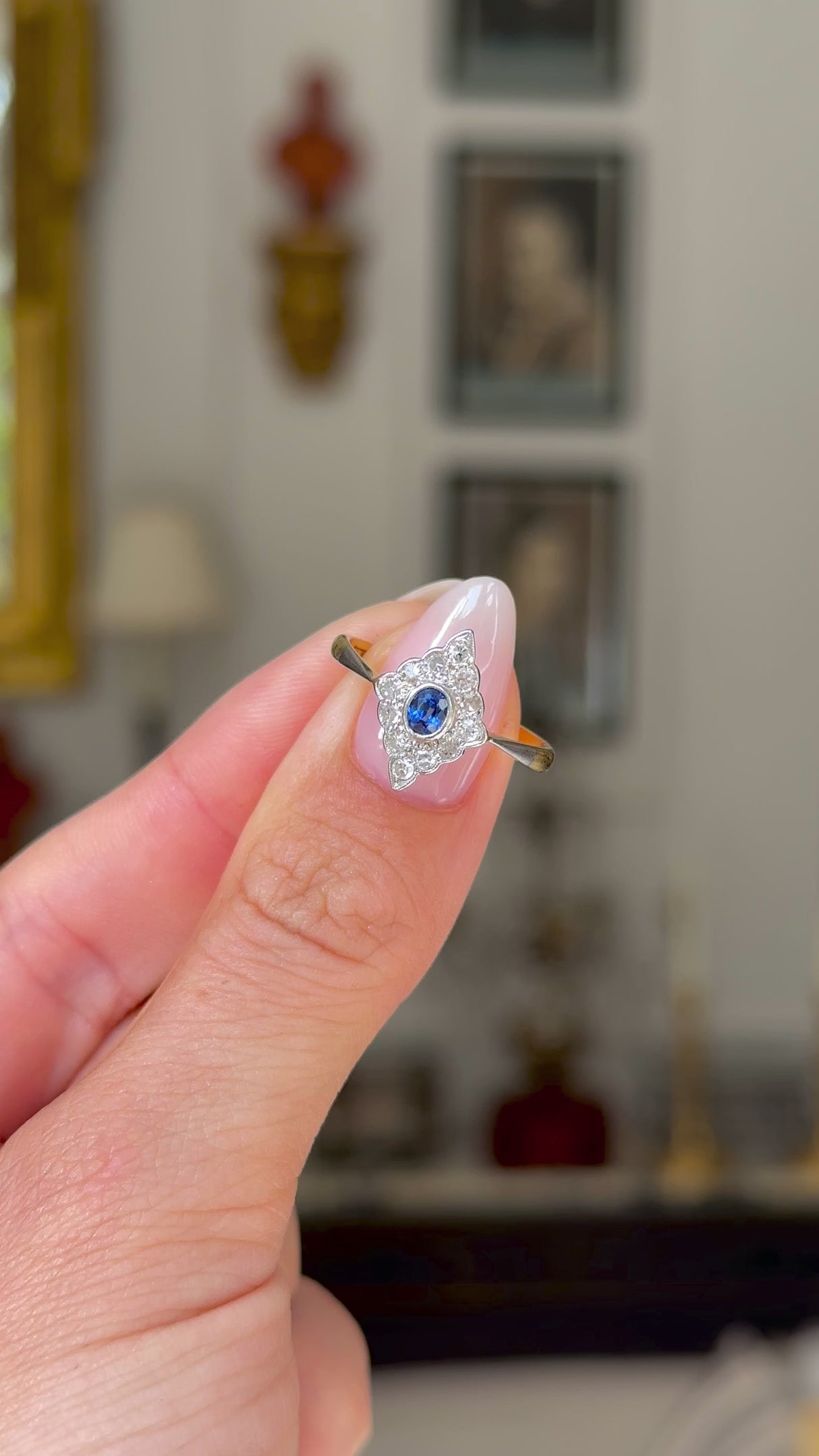 antique edwardian sapphire and diamond kite shaped ring, held in fingers and rotated to give perspective, front view