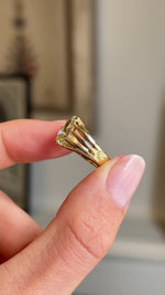 An Antique, Edwardian yellow pear-cut diamond solitaire gypsy ring in yellow gold  held between two fingers rotated slowly to show the profile of the ring and the unusual yellow diamond