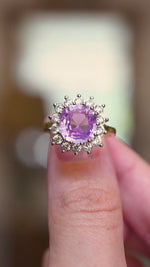 A video showing a vintage-inspired ring with a Ceylon pink sapphire at its centre and a halo of brilliant-cut round diamonds in 14ct white and yellow gold.