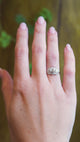 Antique Edwardian diamond cluster ring worn on hand with old cut diamonds.