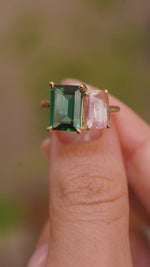 A video of Vintage-inspired, Green tourmaline and pink sapphire Toi et Moi engagement ring in yellow gold held between the fingers and rotated to show different angles.