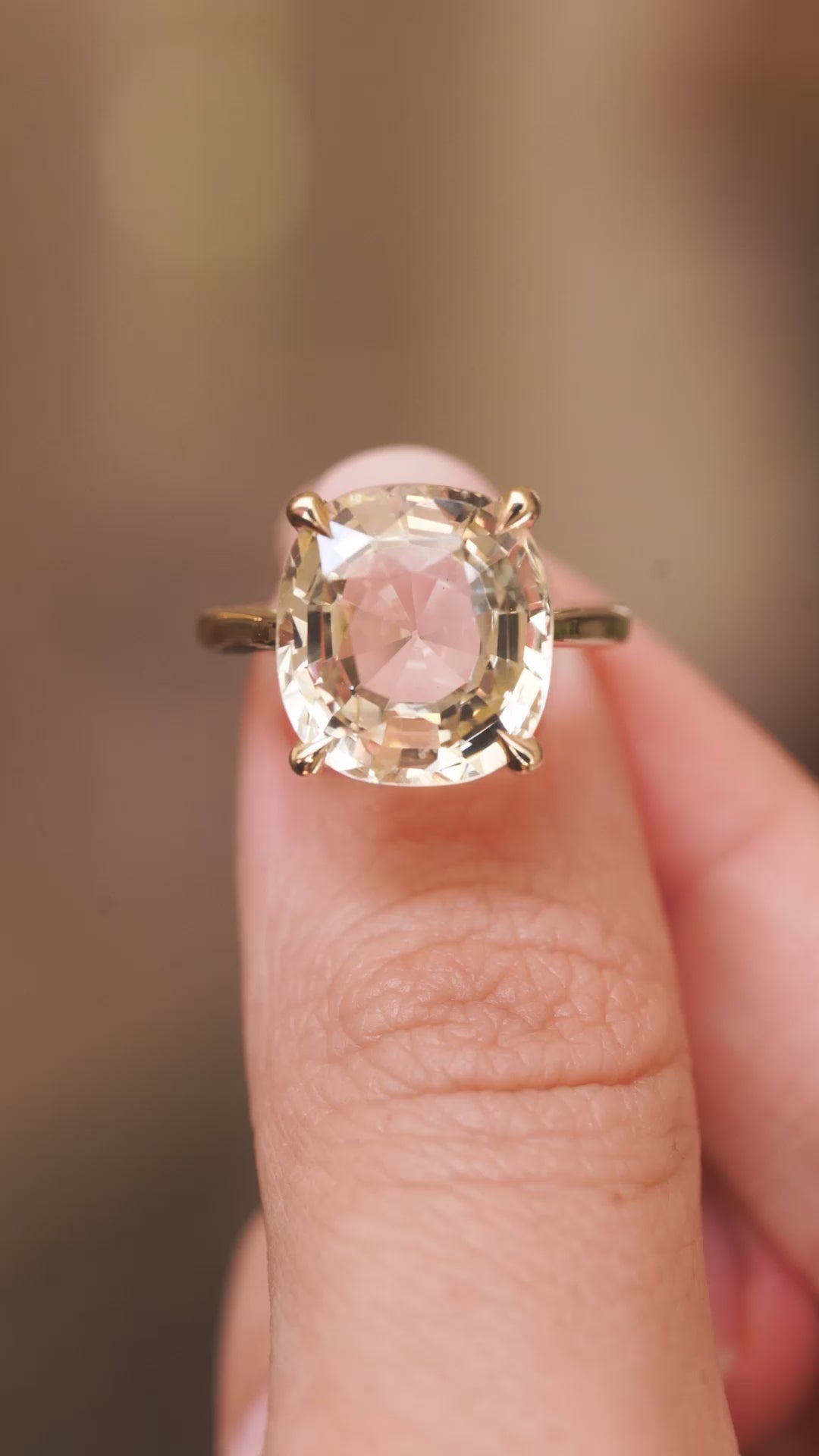 A video of a yellow gold Antique-inspired, Yellow sapphire solitaire engagement ring held between the fingers and rotated to show off all the angles