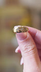 Close detail video of antique Edwardian three-stone diamond gypsy ring with star-set diamonds between fingers.
