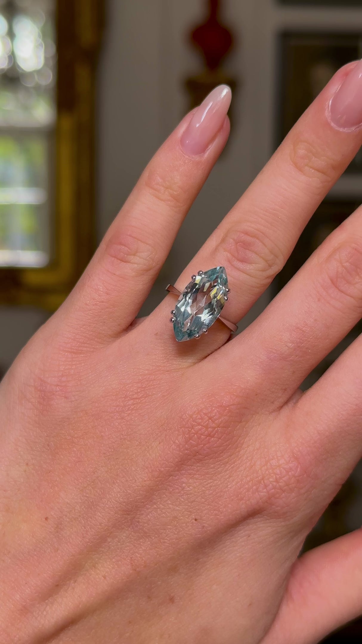 vintage marquise cut aquamarine ring, worn on hand and moved away from lens to perspective, front view. 