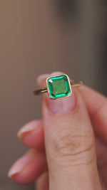 Video presenting the antique-inspired emerald solitaire ring balanced on a fingertip for a detailed face-on look.