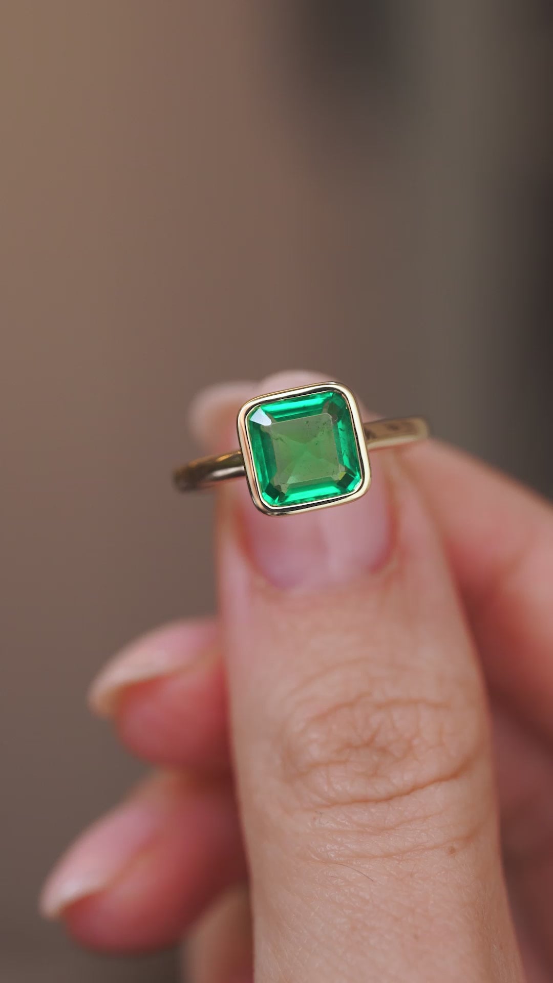 Video presenting the antique-inspired emerald solitaire ring balanced on a fingertip for a detailed face-on look.