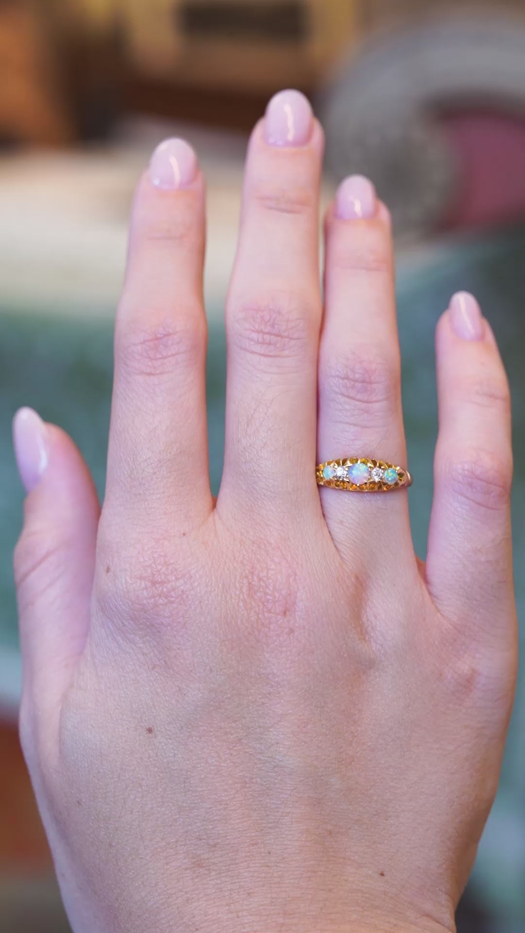 Antique late Victorian opal and diamond five-stone ring worn on hand in motion.
