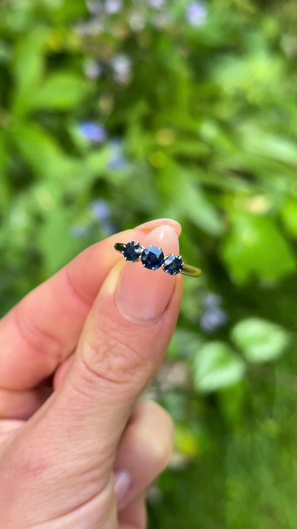 Antique, Edwardian Sapphire Three-Stone Ring, 18ct Yellow Gold held in fingers.