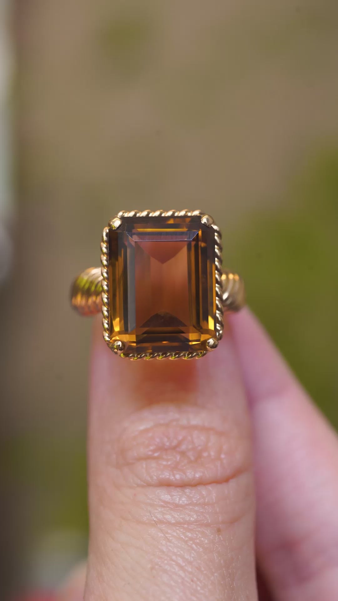 A video of a close detail of a vintage Cartier smoky quartz cocktail ring with an emerald-cut smoky quartz.