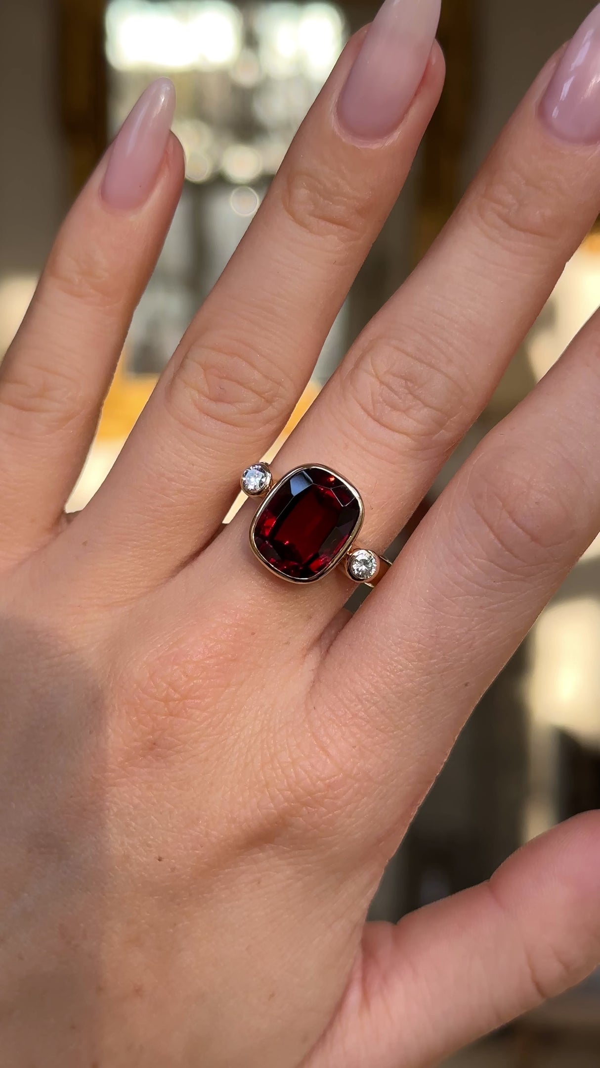 Vintage red zircon and diamond three stone ring worn on hand and moved around to give perspective.