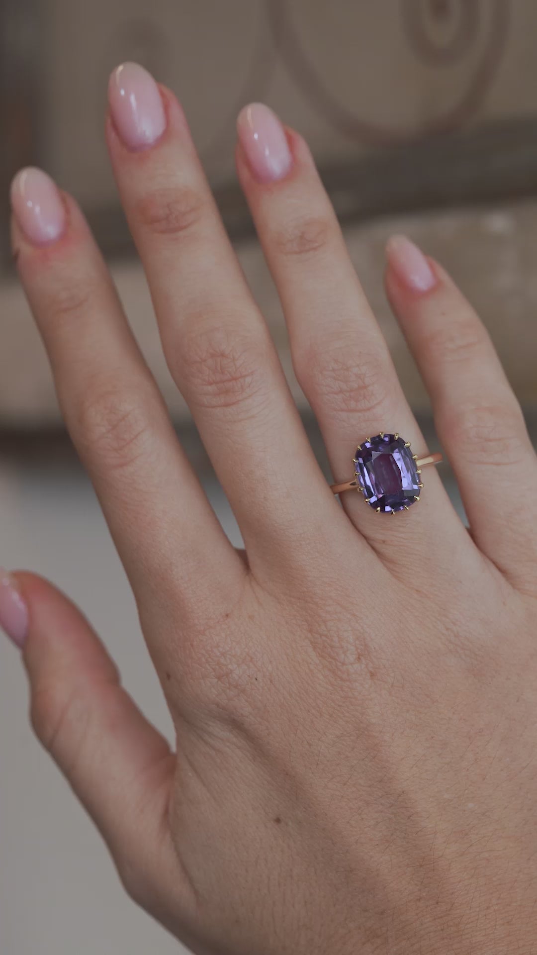 A video of the colour change sapphire ring worn on a finger, capturing the gemstone's violet and blue tones.