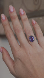 A video of the colour change sapphire ring worn on a finger, capturing the gemstone's violet and blue tones.