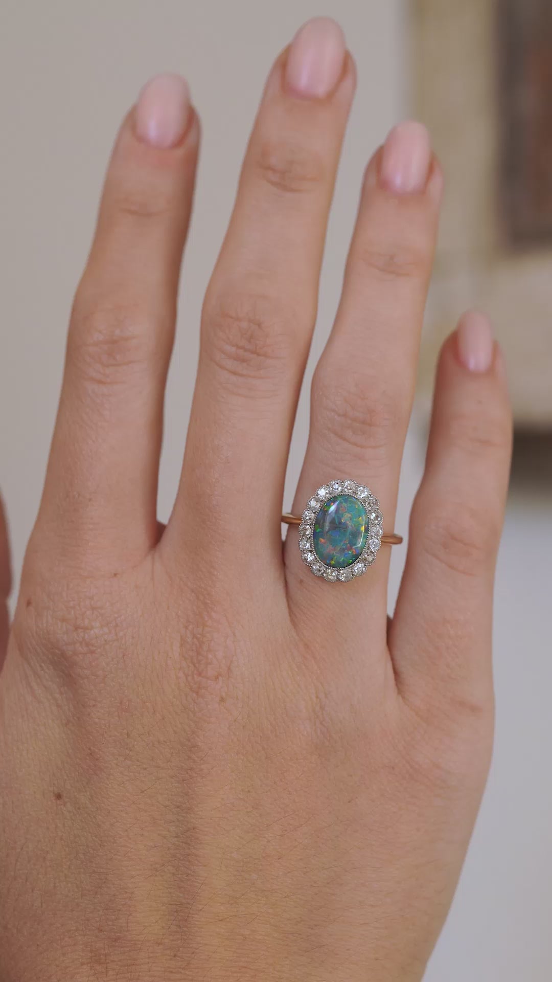 Video showcasing the Edwardian black opal and diamond ring on the hand as the gemstone’s colours shift in the light.