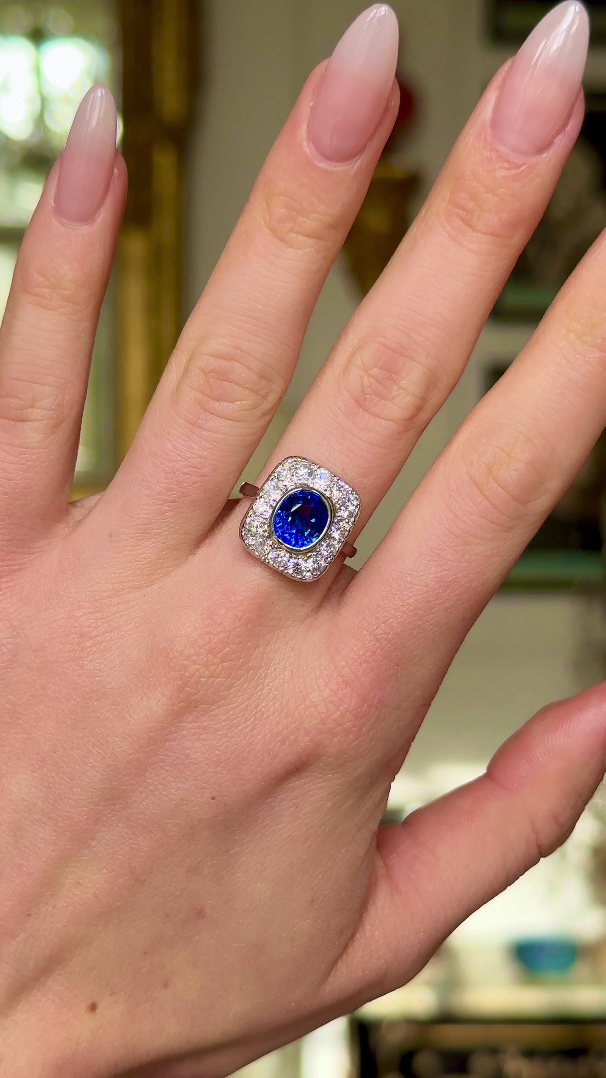 Art Deco sapphire and diamond cluster ring, worn on hand and moved around to give perspective.