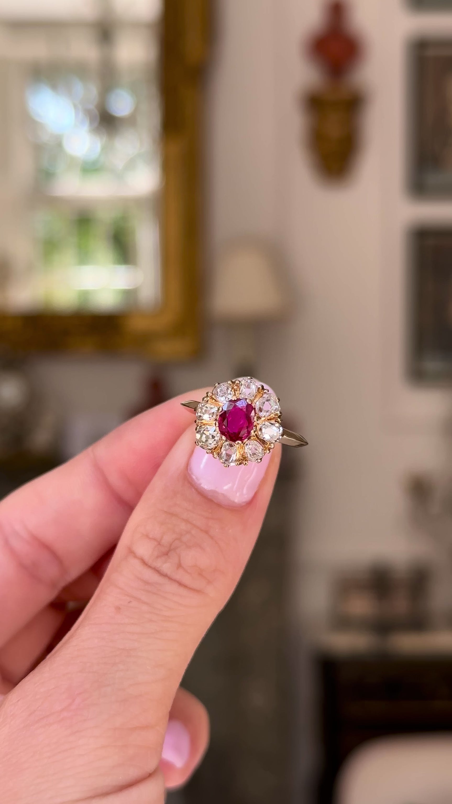 antique ruby and diamond cluster, held in fingers and rotated to give perspective, front view.