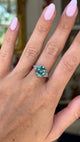 Art deco blue zircon and diamond ring, worn on hand and moved away from lens to give perspective, front view. 