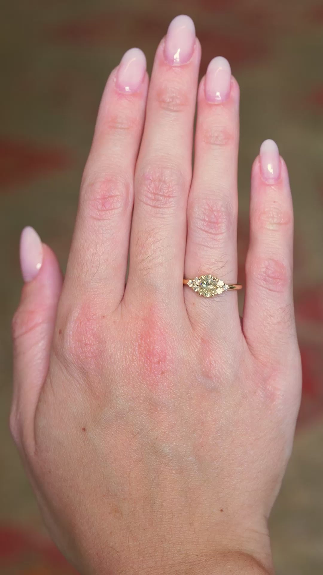 Antique-inspired primrose yellow diamond cluster tre-foil engagement ring worn on hand showing subtle motion.