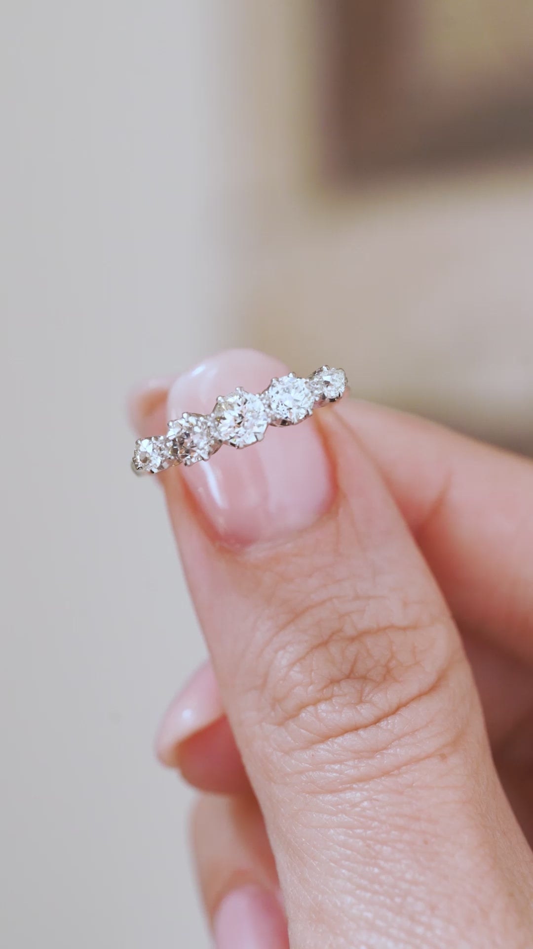 Video close-up of the Edwardian diamond ring balanced on a fingertip, highlighting its graduated proportions and platinum claws.