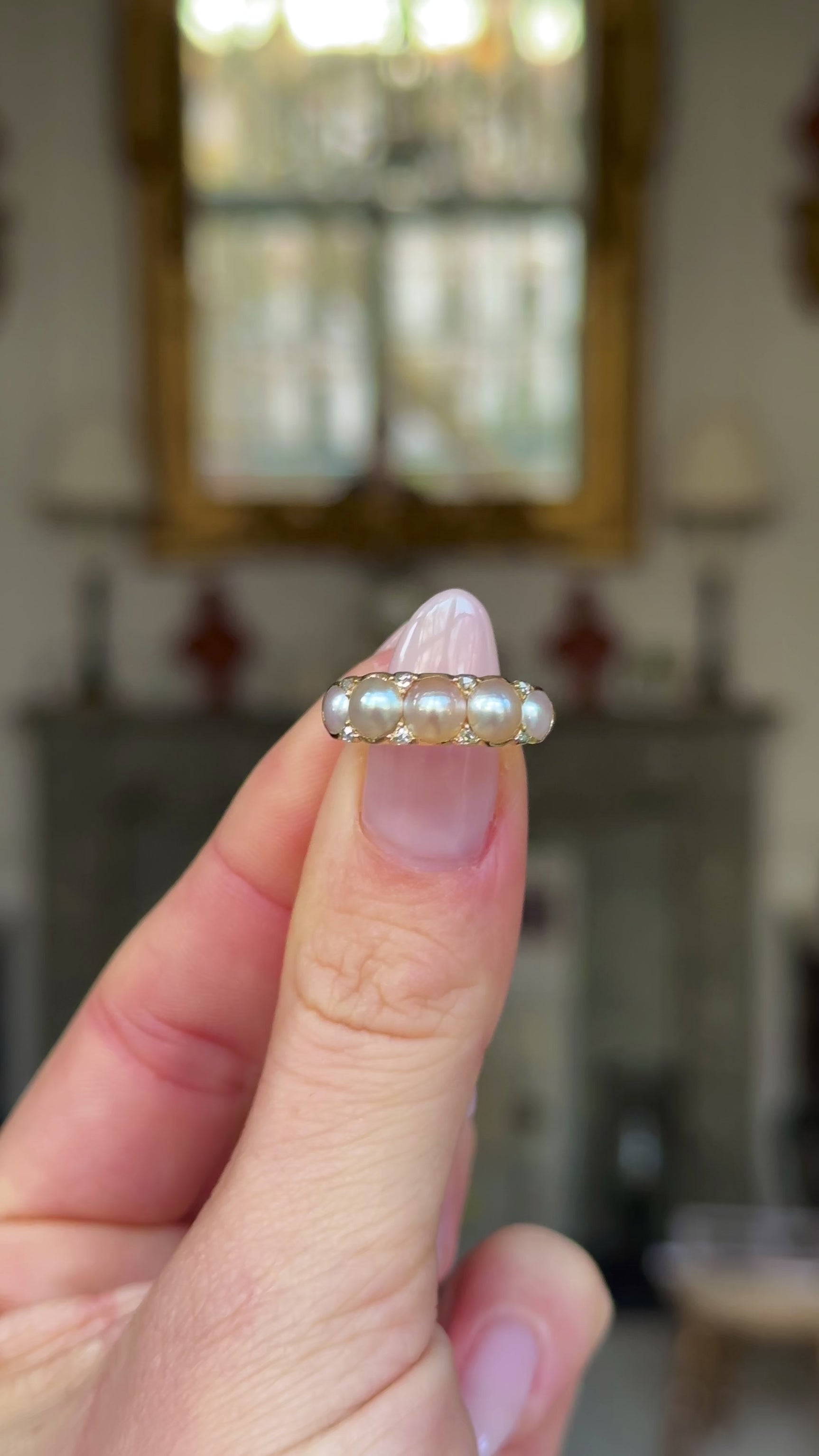 Georgian pearl half hoop ring held in fingers and moved around to give perspective.