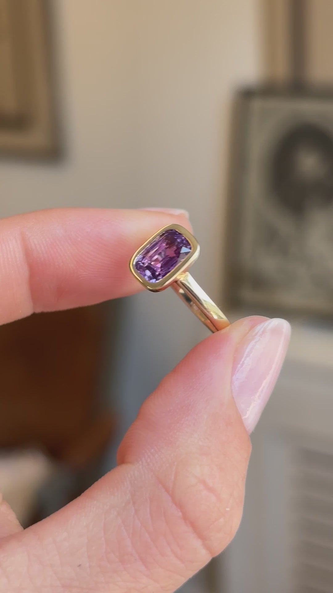 Royal purple cushion-cut sapphire solitaire engagement ring featuring a vibrant cushion-cut purple sapphire in a timeless solitaire design, held by hand for detailed viewing.