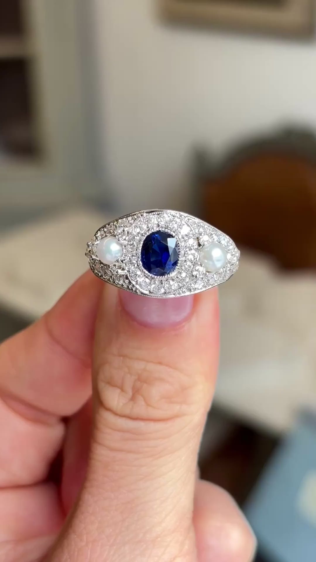 Close up video of a dark blue sapphire and pearl Antique, Belle Époque cluster cocktail ring in white gold. 