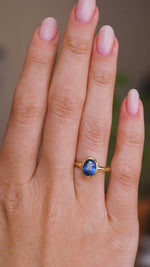 A video of a solitaire engagement ring worn on a wedding finger.  Rotated slowly to display the antique-inspired yellow gold bezel setting of the Sri Lankan blue sapphire and the profile of the setting and band once worn. 