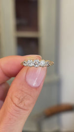 Antique Victorian old-mine diamond five-stone ring showcasing five graduated old-mine cut diamonds, held by hand to highlight the setting and craftsmanship.