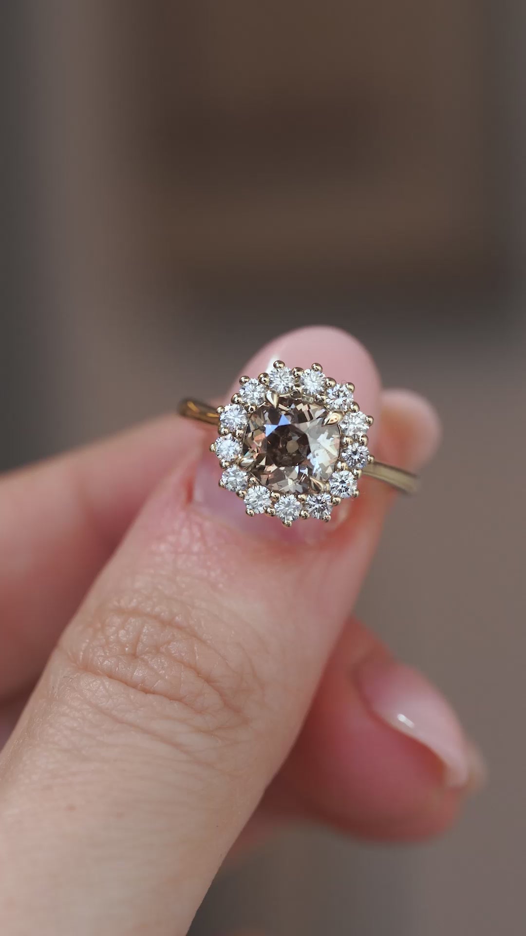 A close-up video of the smoky cognac diamond ring held between fingers, capturing its warm tones and sparkle.