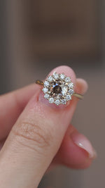 A close-up video of the smoky cognac diamond ring held between fingers, capturing its warm tones and sparkle.