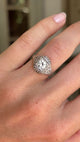 Antique Art Deco diamond cluster ring with intricate openwork detailing and diamond set geometric cluster, featured on a hand.