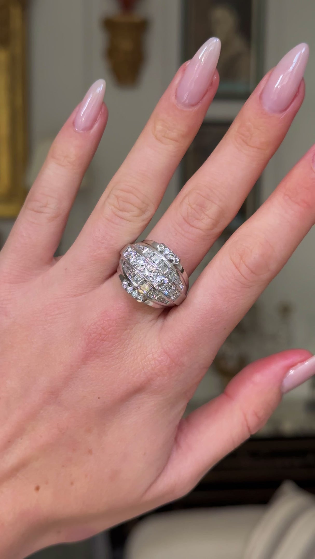 impressive Art Deco diamond bombe ring, worn on hand and moved away form lens to give perspective, front view. 