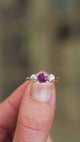 Ruby ring with diamond side stones showing light reflections and three stone design.