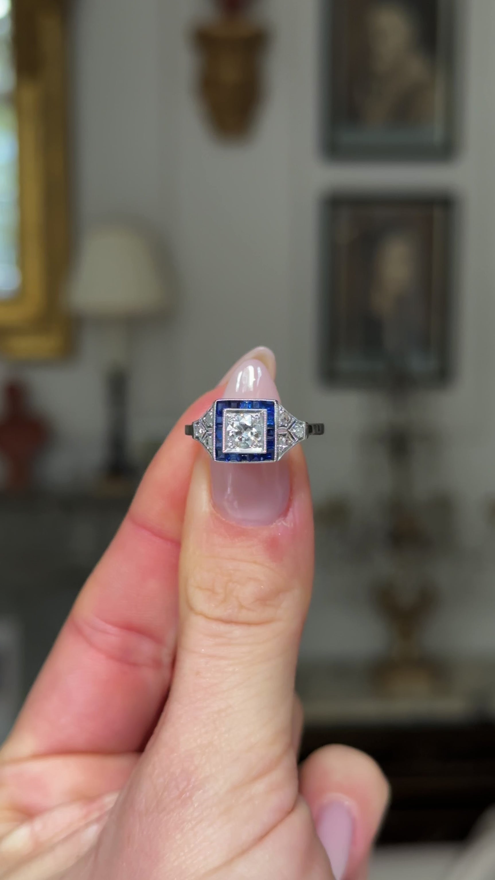 Vintage sapphire and diamond engagement ring, held in fingers and moved around to give perspective.