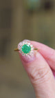 Emerald and diamond cluster ring close view with natural light.