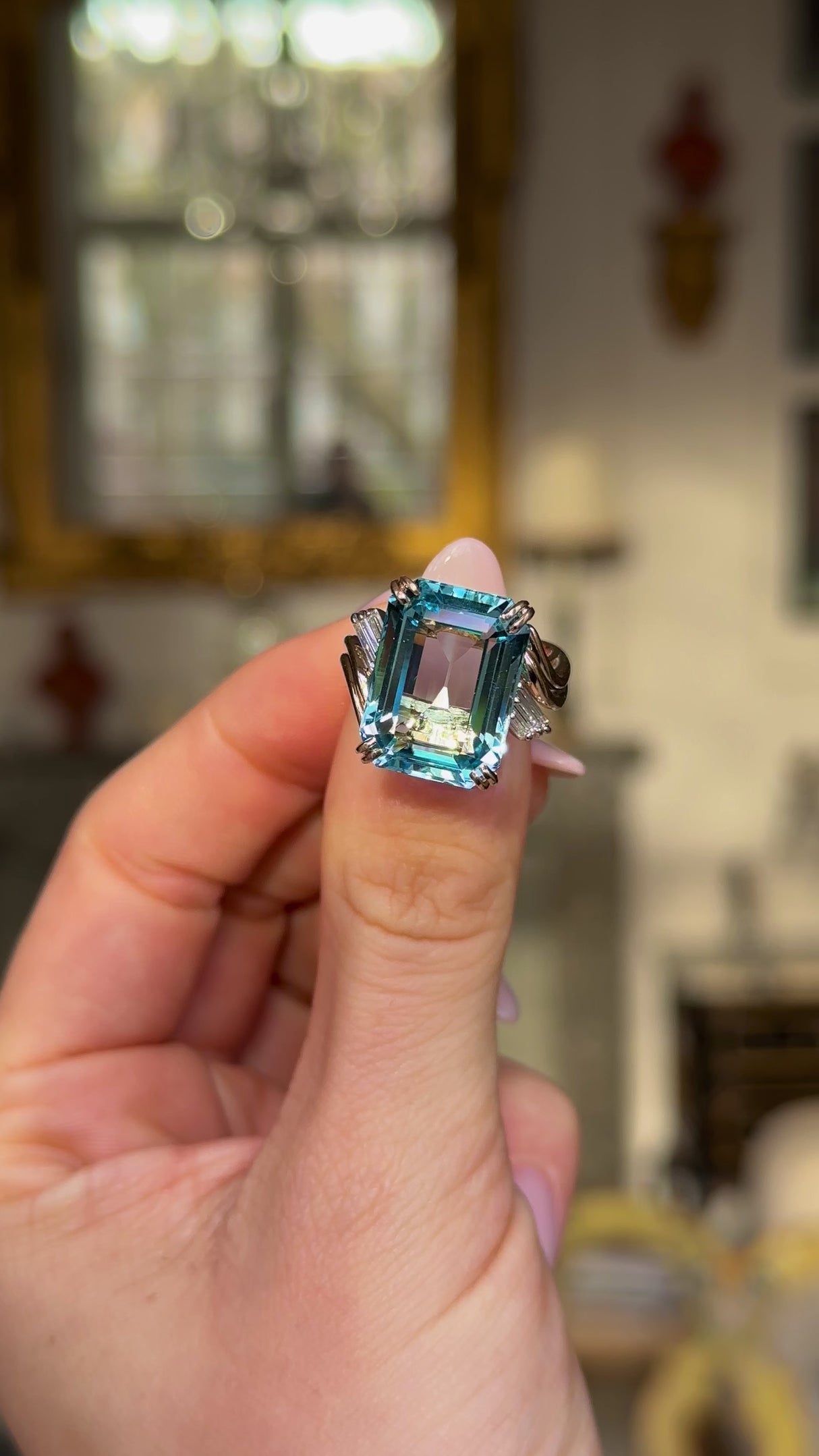 vintage aquamarine and diamond ring held in fingers and moved around to give perspective. 