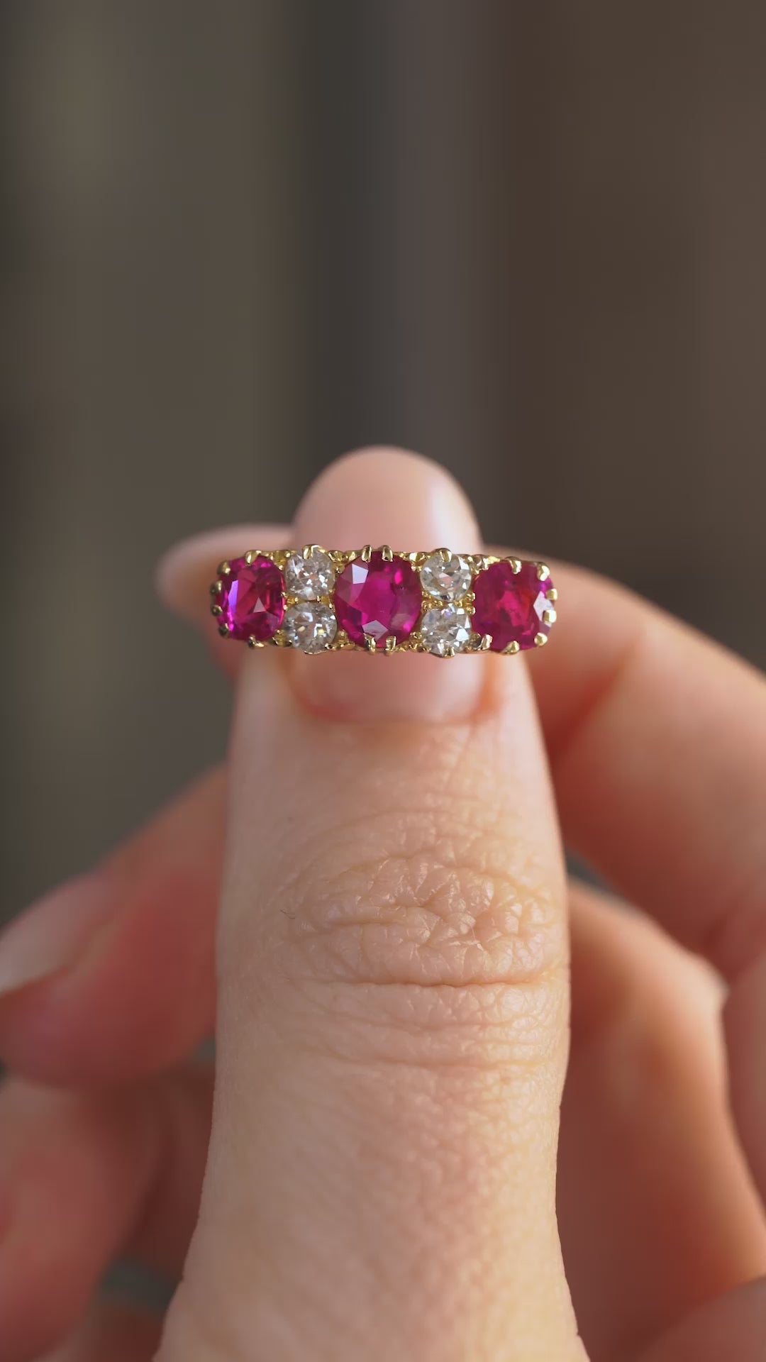Video presenting the Edwardian ruby and diamond engagement ring balanced on a fingertip as the gemstones catch the light.